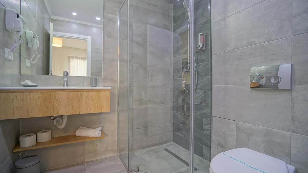 a bathroom with a shower and a toilet and a sink at Monarch House in Braşov