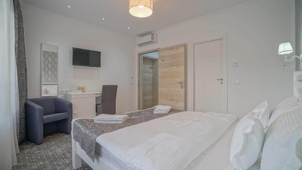 a bedroom with a bed and a desk and a chair at Monarch House in Braşov