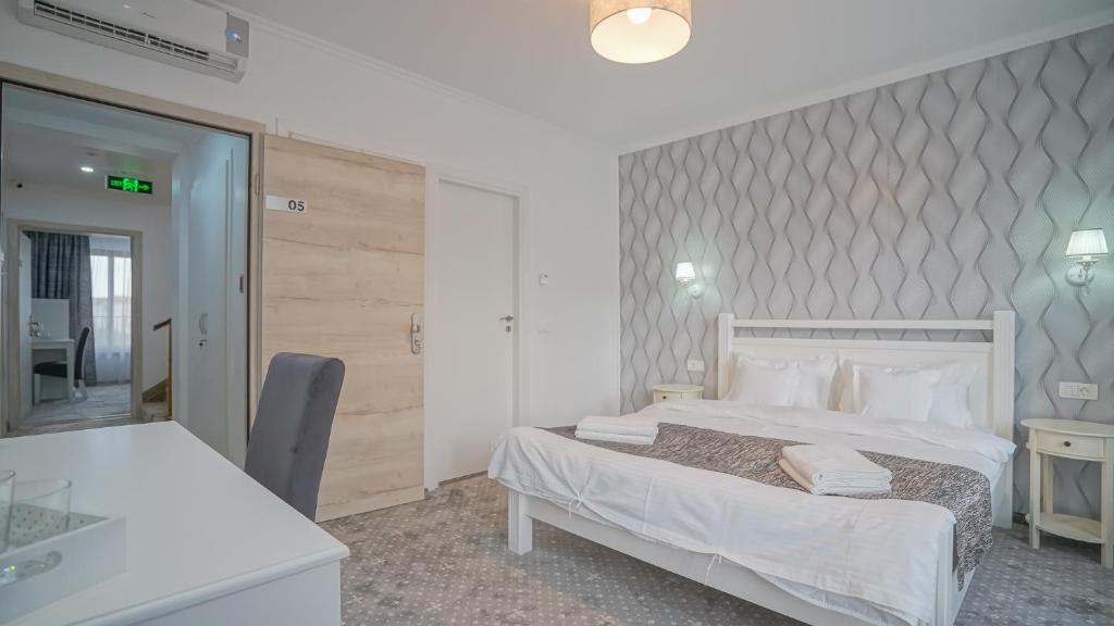 a hotel room with a bed and a desk at Monarch House in Braşov