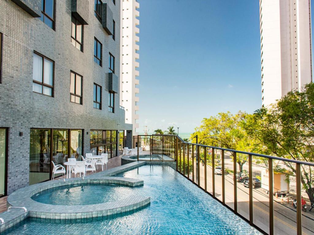 a swimming pool on the balcony of a building at Ilusion Hotel in Natal