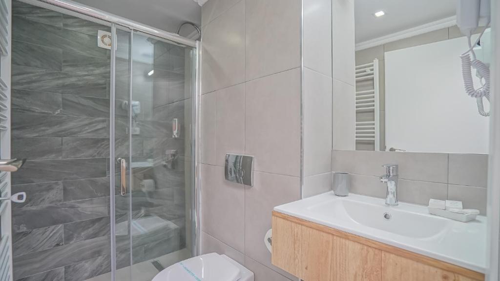 a bathroom with a shower and a sink and a toilet at Monarch House in Braşov