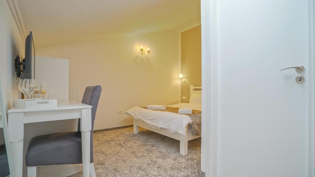 a bedroom with a bed and a table and a desk at Monarch House in Braşov
