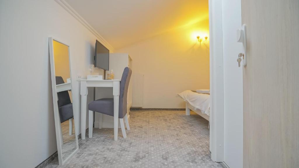 a small room with a desk and a bed at Monarch House in Braşov