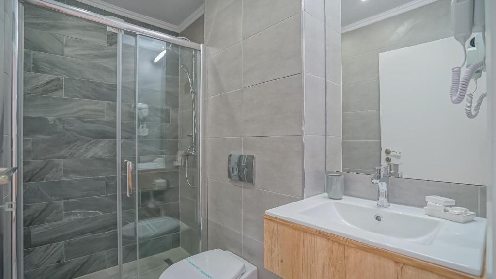 a bathroom with a shower and a sink and a toilet at Monarch House in Braşov