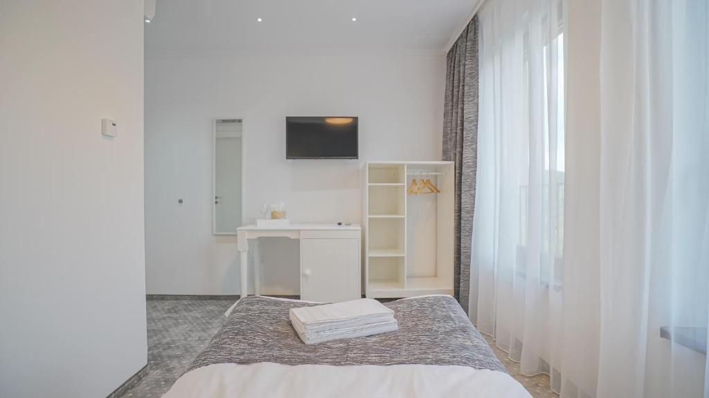 a white room with a bed and a sink at Monarch House in Braşov