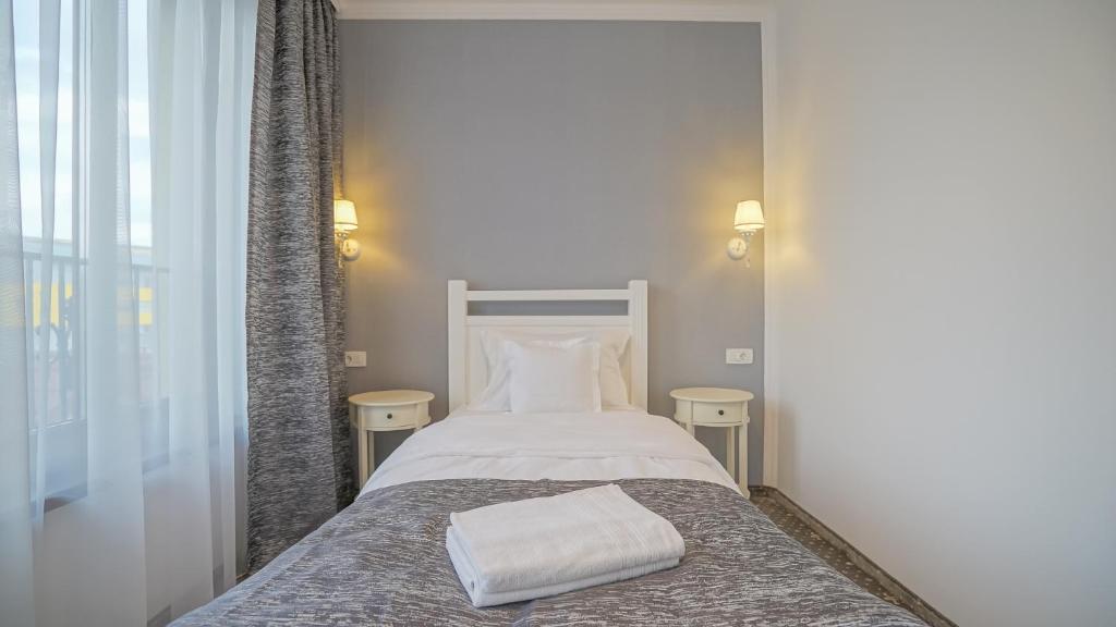 a bedroom with a bed with a towel on it at Monarch House in Braşov