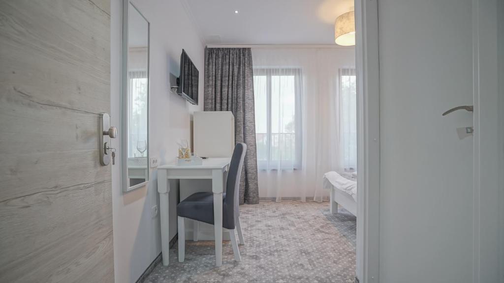 a room with a desk and a table with a chair at Monarch House in Braşov