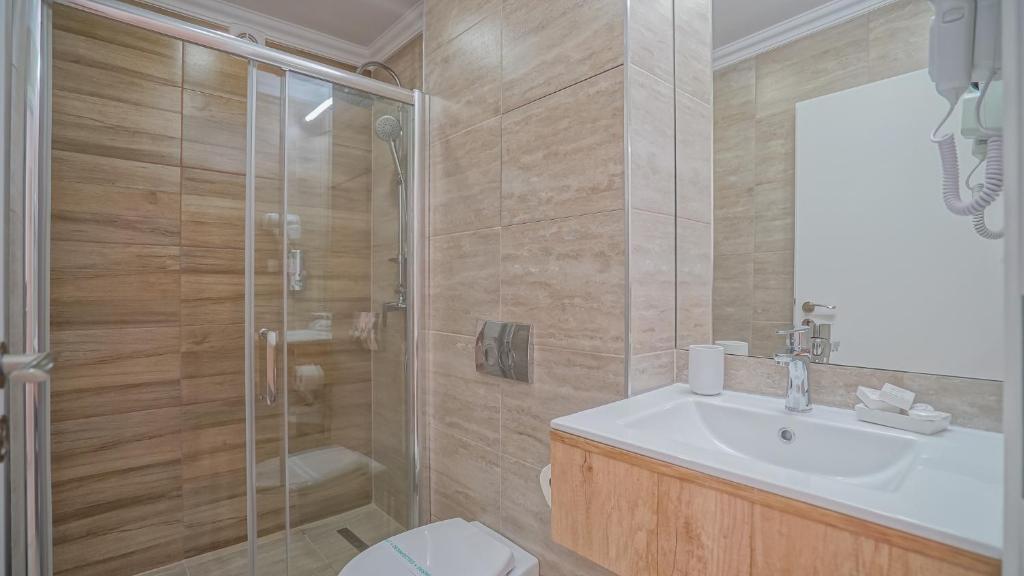 a bathroom with a shower and a sink and a toilet at Monarch House in Braşov