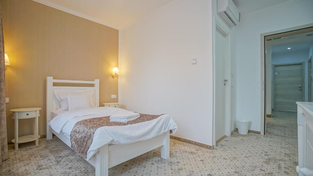 a bedroom with a white bed in a room at Monarch House in Braşov