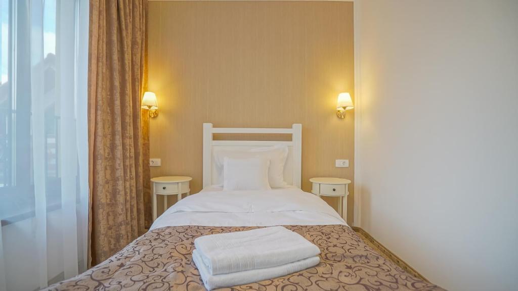 a bed with two pillows on it in a room at Monarch House in Braşov