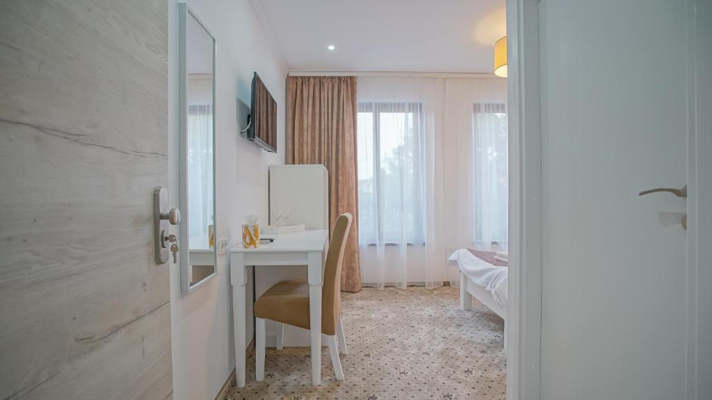 a room with a desk with a mirror and a table at Monarch House in Braşov