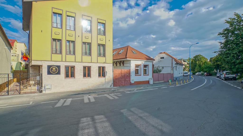a yellow building on the side of a street at Monarch House in Braşov