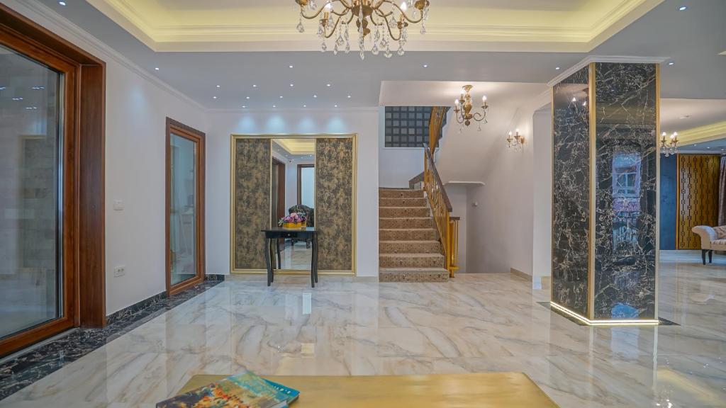 a living room with a staircase and a chandelier at Monarch House in Braşov
