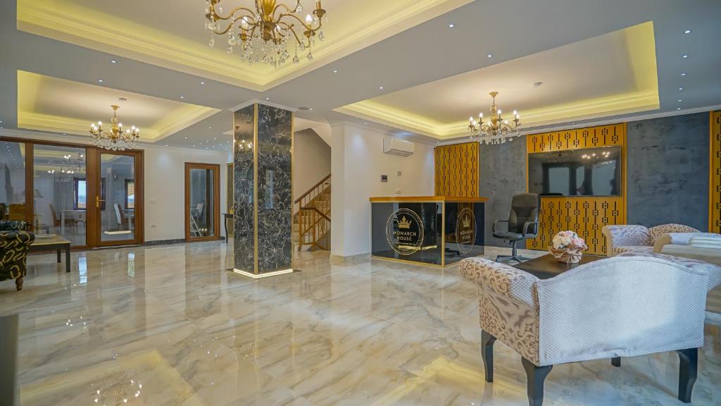 a living room with a chandelier and a table and chairs at Monarch House in Braşov