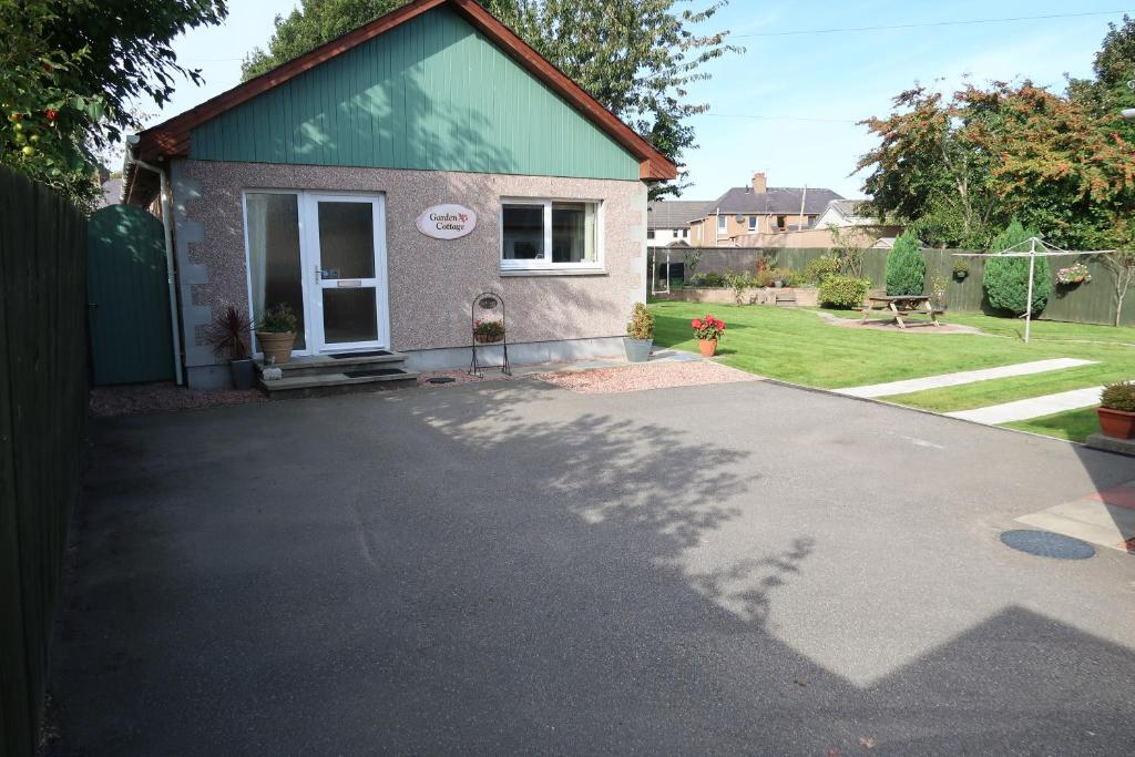 a house with a driveway in front of it at Corunna Cottage in Inverness
