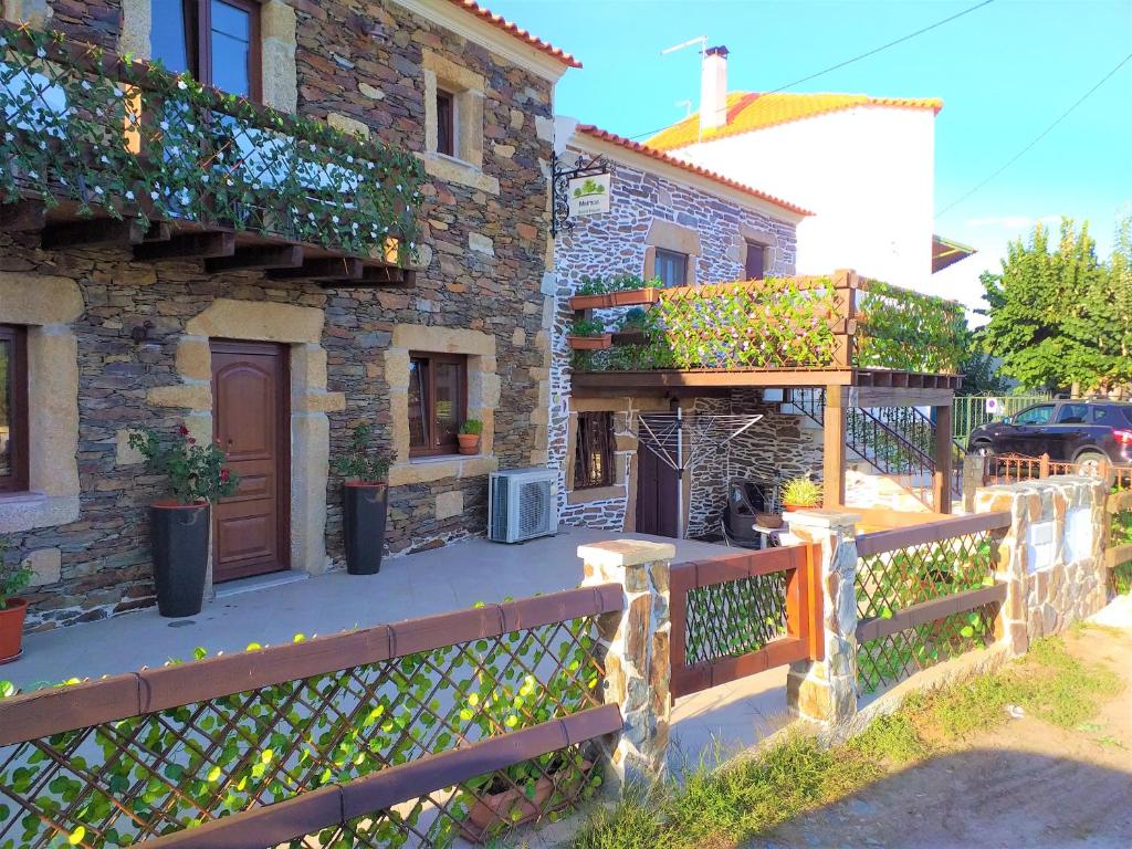 uma casa de pedra com uma cerca e um porto em Meimoa Guesthouse em Meimoa