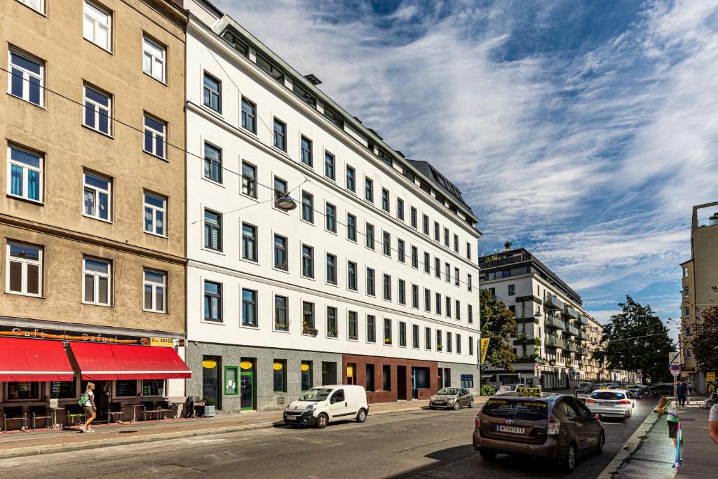 a large white building on a city street with cars at Ley Apartments Vienna in Vienna