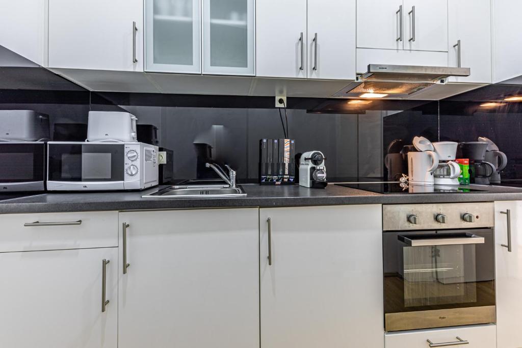 a white kitchen with white cabinets and appliances at Ley Apartments Vienna in Vienna