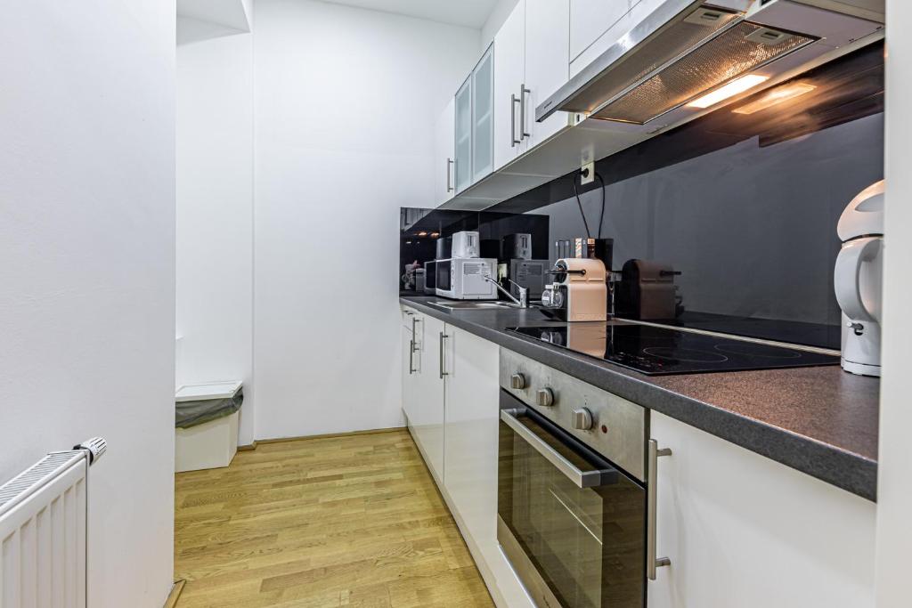 a kitchen with white cabinets and a counter top at Ley Apartments Vienna in Vienna