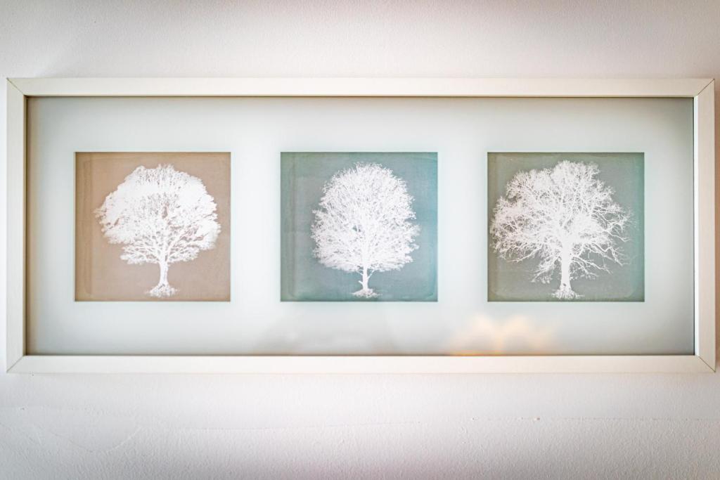 a framed picture of three trees on a wall at Ley Apartments Vienna in Vienna