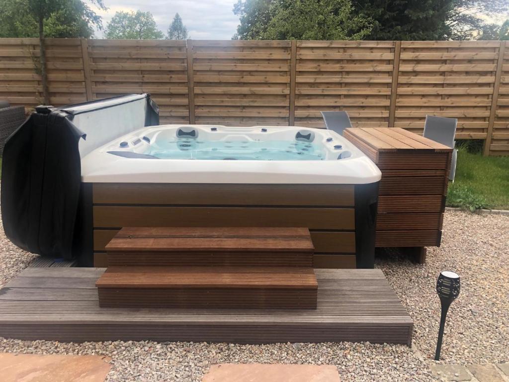 a jacuzzi tub sitting on a wooden deck at La Sentinelle Gite in Spa