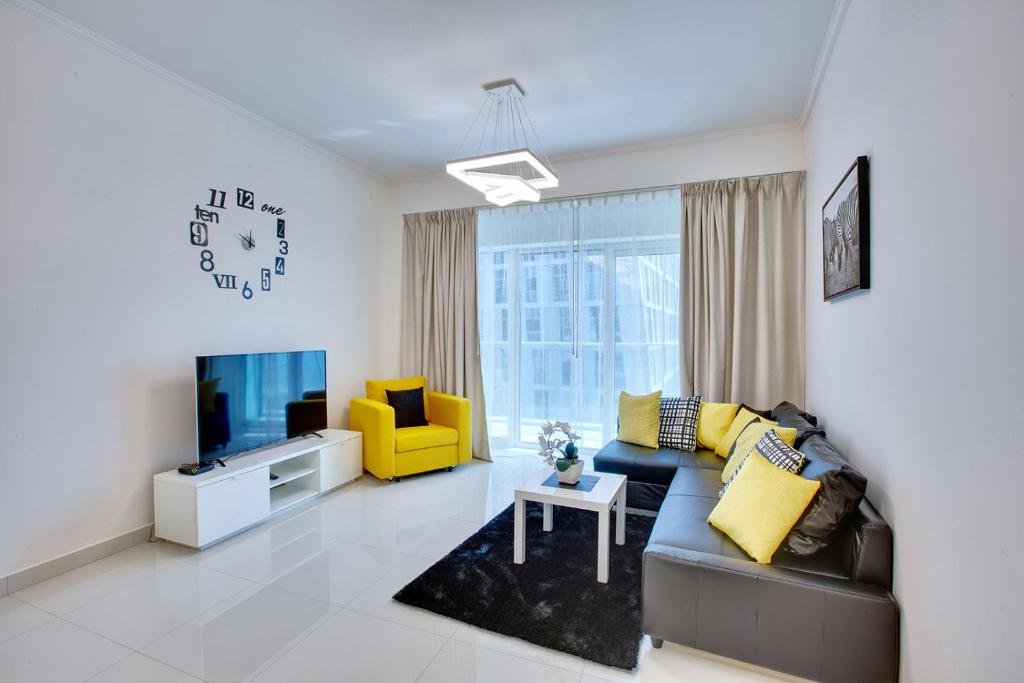 a living room with a couch and a tv at Ultra modern 1BD in Damac Heights Marina in Dubai