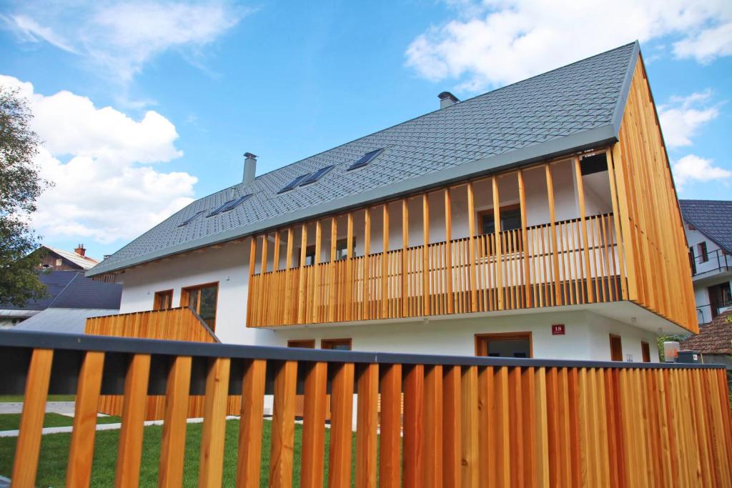 a house with a wooden fence in front of it at Apartment Jurijana - New 4-Bedroom Triplex with Sauna & Garden in Bohinj