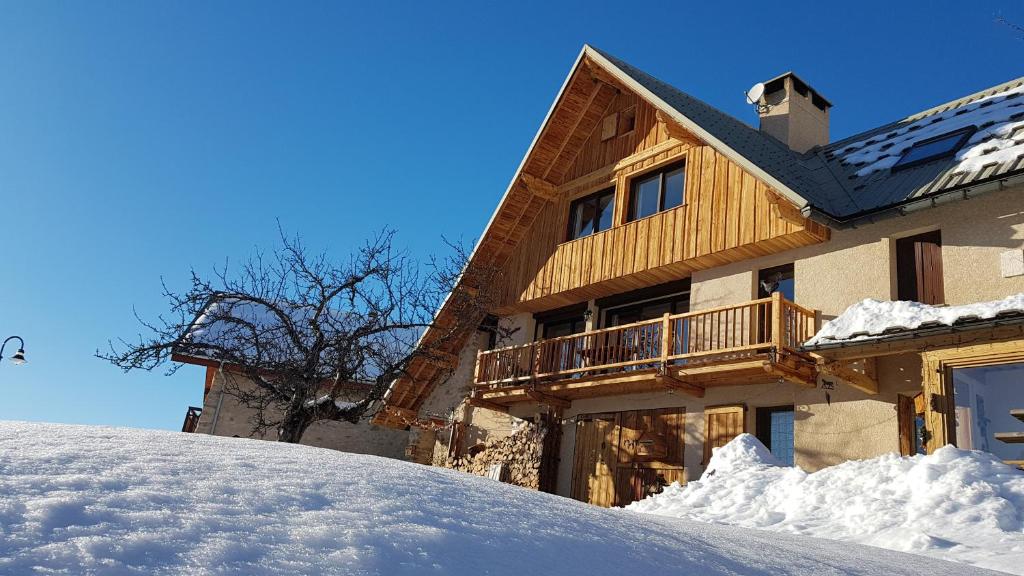 uma casa de madeira com neve em frente em Chalet la Forestière em Orcières