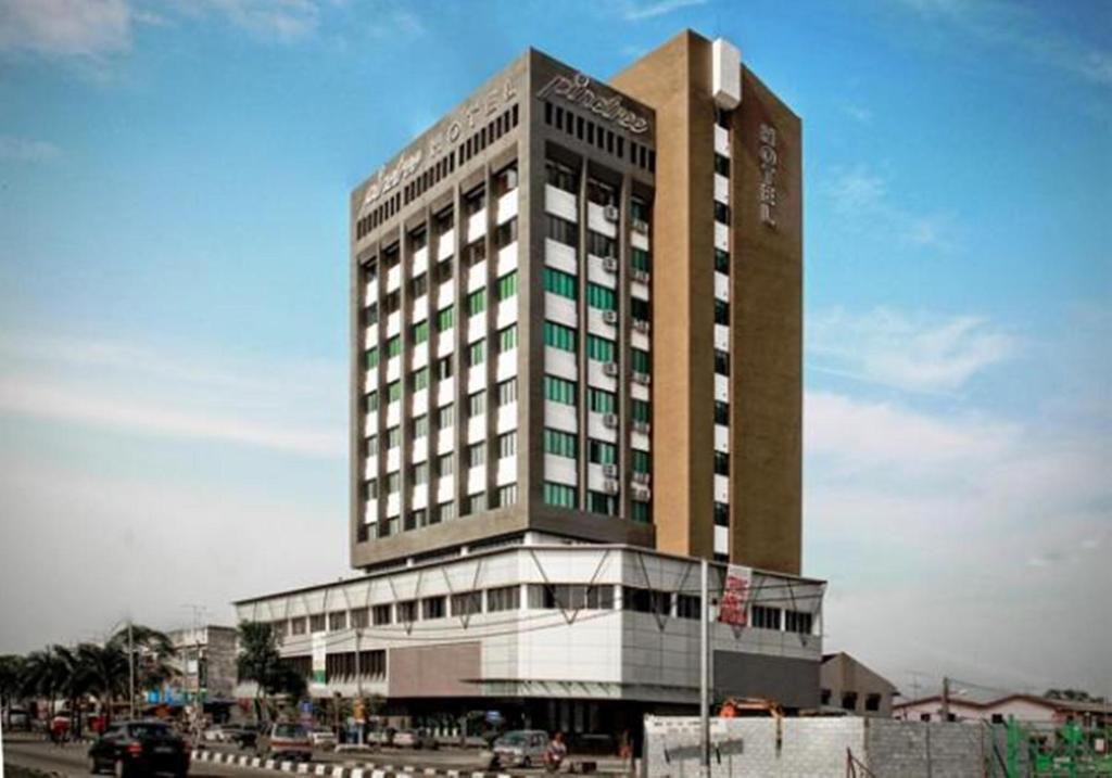 a tall building in front of a building at Pine Tree Hotel in Batu Pahat