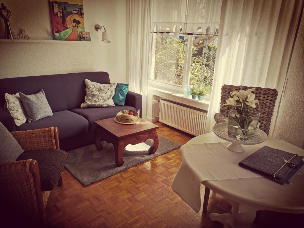 "Maison Blanche" - das gemütliche Garten-Apartment zwischen Köln und Düsseldorf في غرفنبرويش: غرفة معيشة مع أريكة زرقاء وطاولة