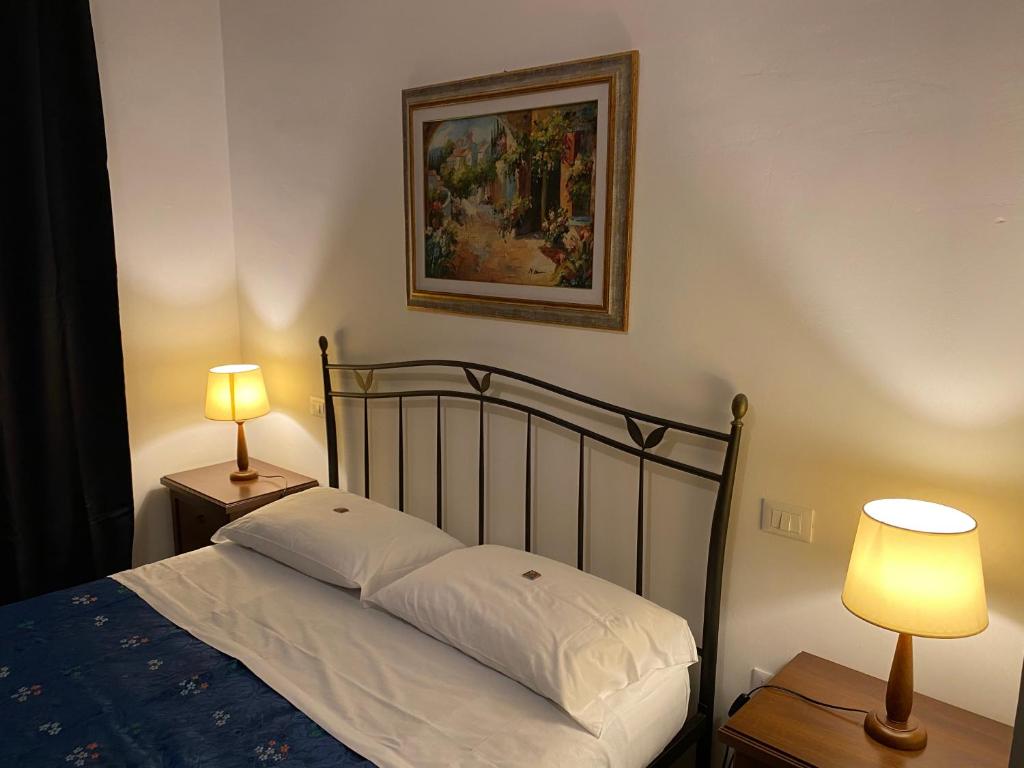 a bed with two lamps and a picture on the wall at Green House in Lanciano