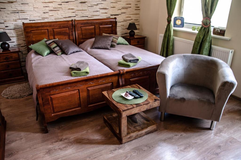 ein Schlafzimmer mit einem Bett, einem Stuhl und einem Tisch in der Unterkunft Apartament w Drawsku in Dramburg