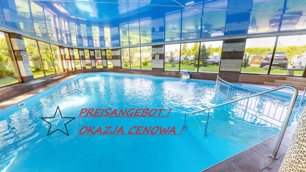 a large swimming pool in a building with windows at Orka in Trzęsacz