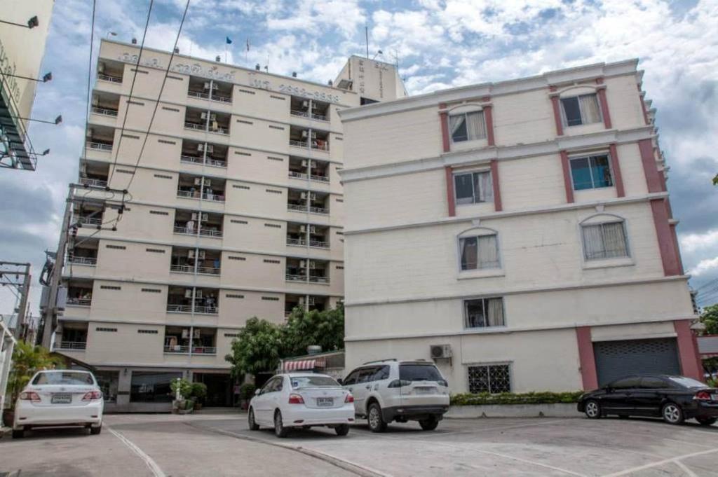 a large white building with cars parked in front of it at S.K. Residence in Bangkok