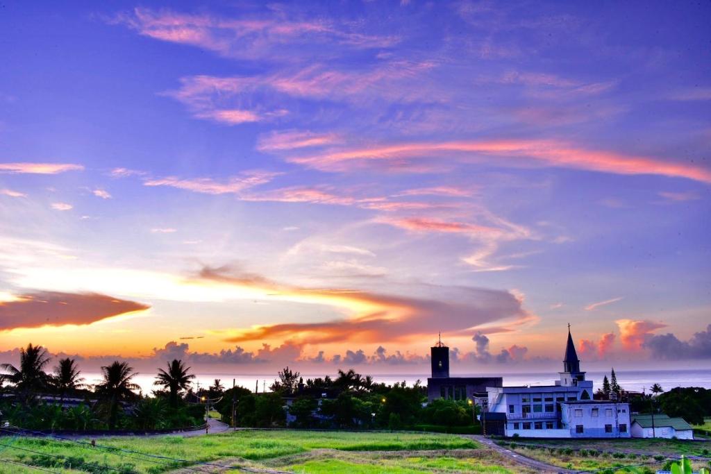 a sunset over a town with a church and a building at Babian Bed and Breakfast in Chenggong