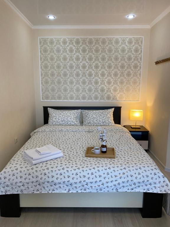 a bedroom with a large bed with a tray on it at Mountain View Apartment in Maykop