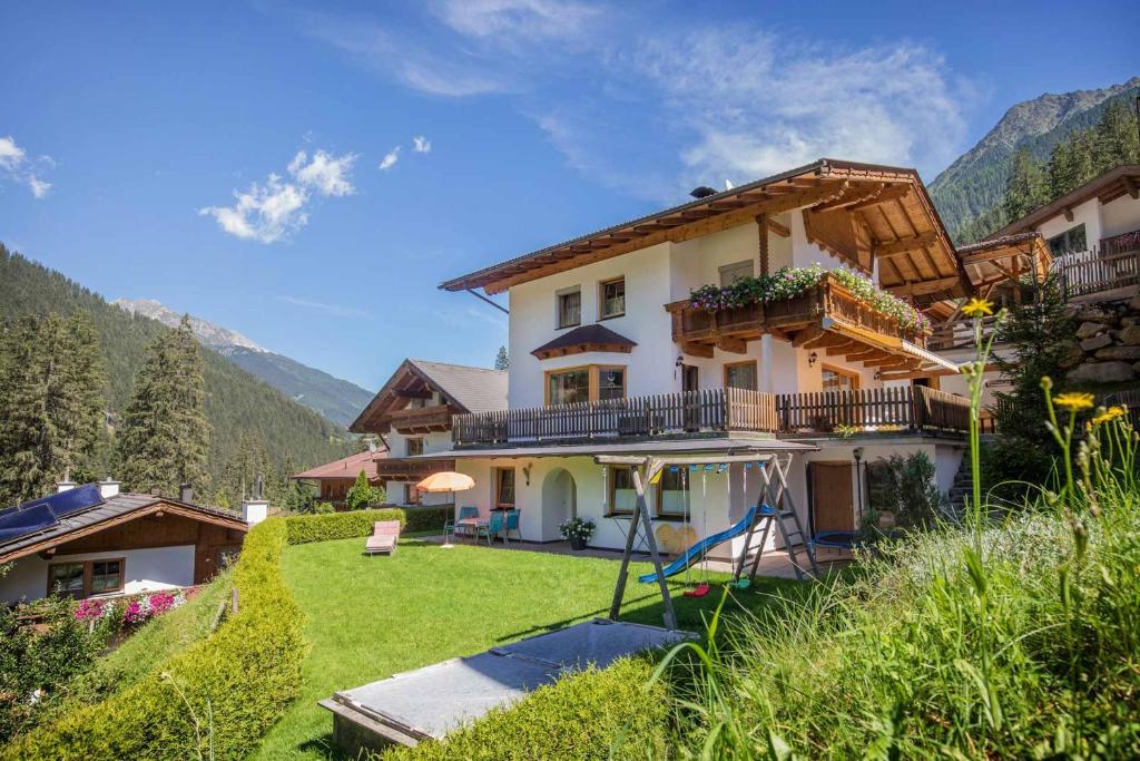 a house on a hill with a green yard at Appartement Ewald Siller in Neustift im Stubaital