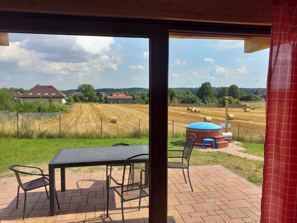 a patio with a table and chairs and a view of a field at Mazurskie Ranczo in Bogaczewo