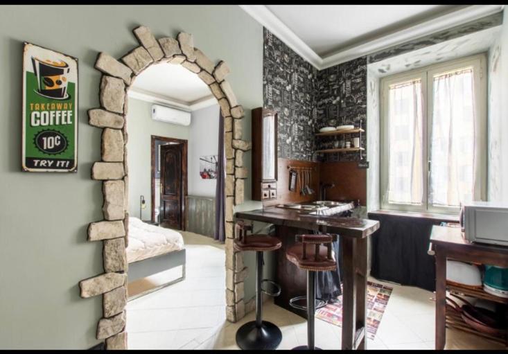 eine Küche mit einem Tisch und einer Steinmauer in der Unterkunft django apartament in Rom