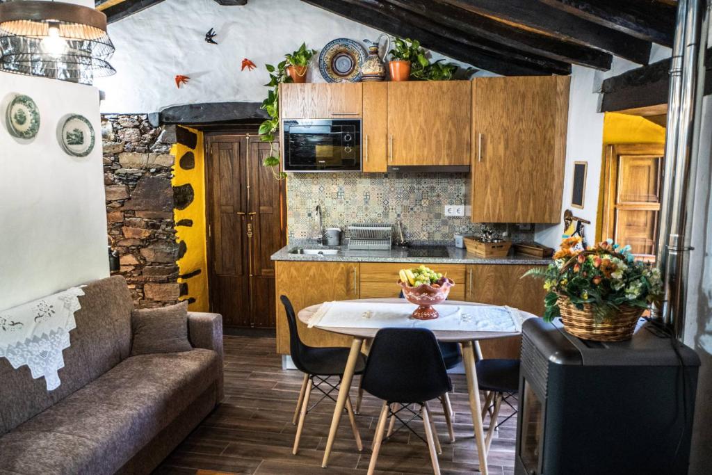 een kleine keuken met een tafel en een bank bij Montanhas do Xisto - Casa da Eira in Candal