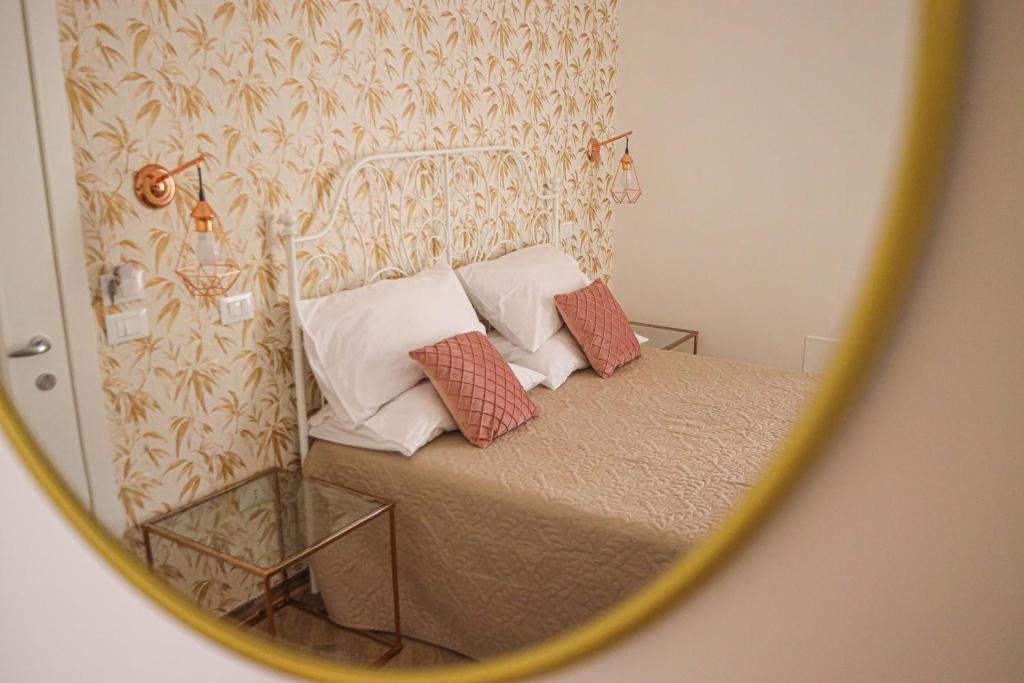 - une réflexion sur un lit avec des oreillers dans un miroir dans l'établissement B&B La Fenice Suite, à Salerne