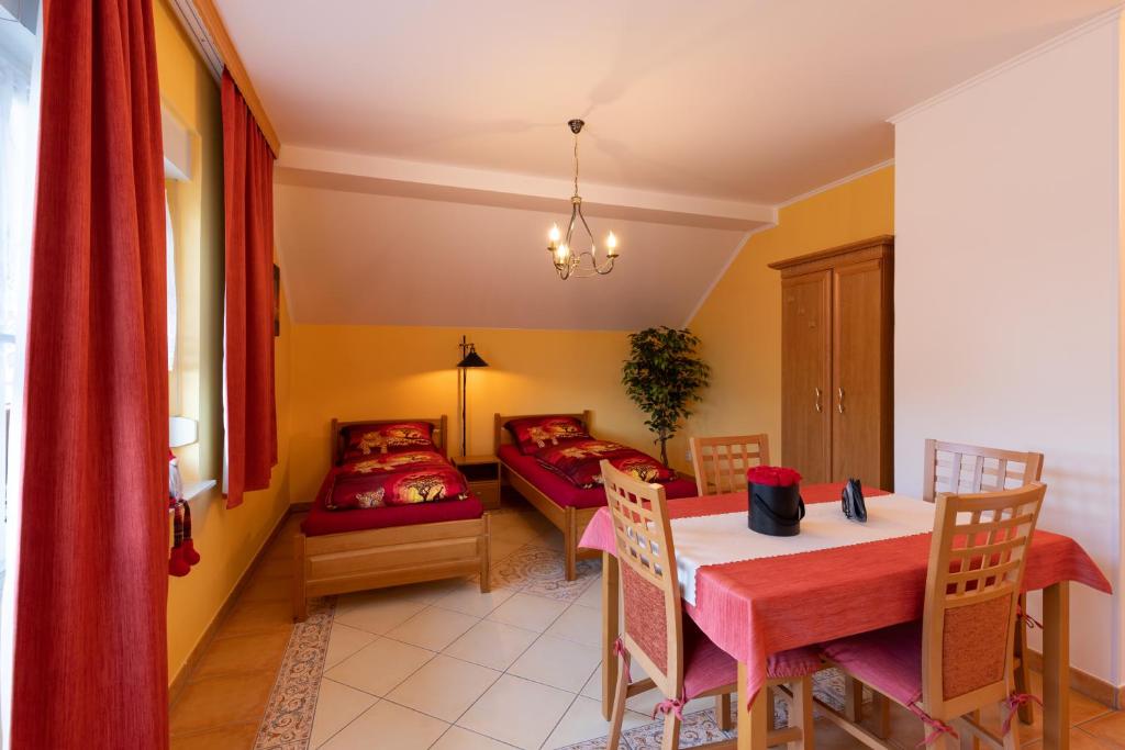 a dining room with a table and a bed at Pension Eric in Ostrov