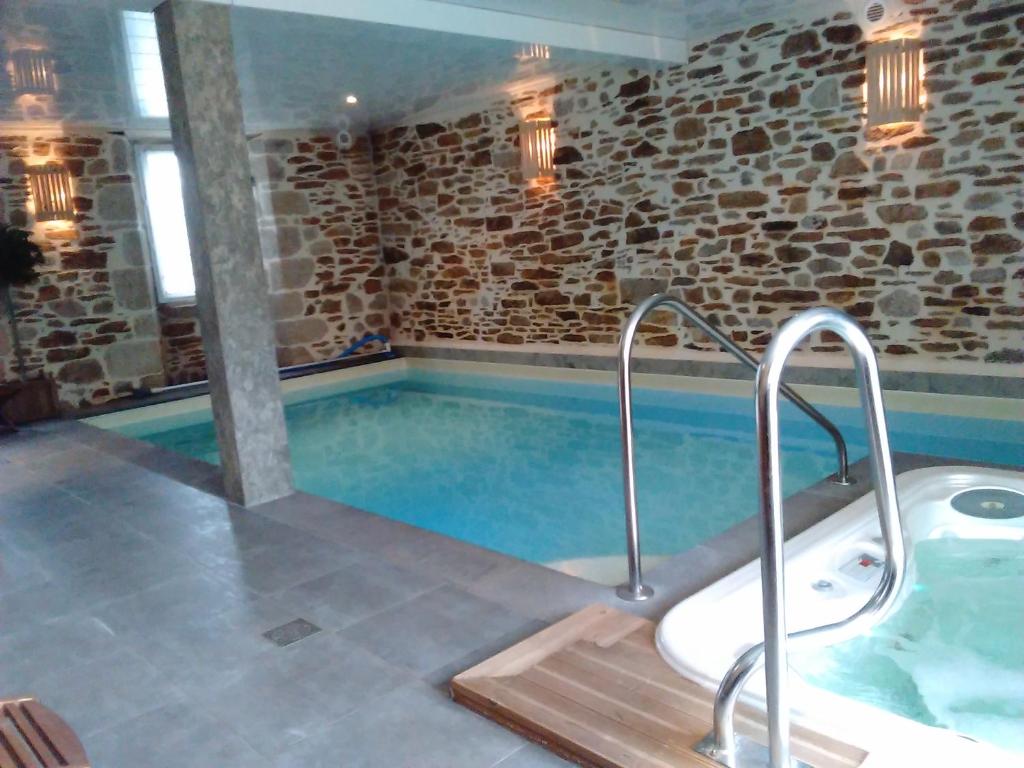 a large pool with a tub in a room at la Maison d'Odette et Daniel in Vitrac