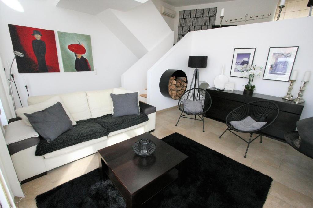 sala de estar con sofá blanco y mesa en Casa Ameixeira, en Ferragudo