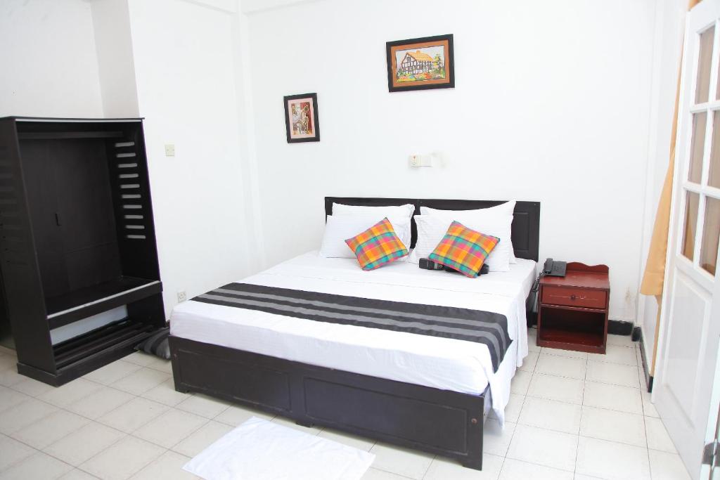 a bedroom with a bed and a flat screen tv at Hotel Nathaliya in Seeduwa