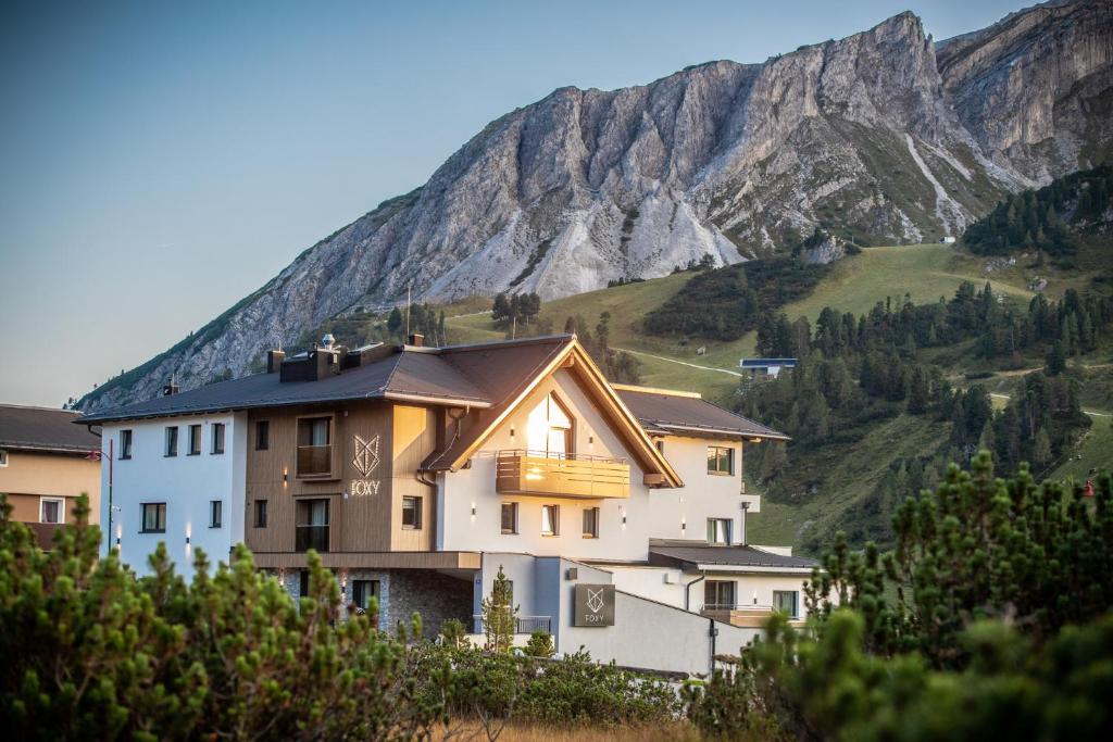 ein Gebäude mit einem Berg im Hintergrund in der Unterkunft FOXY Obertauern in Obertauern