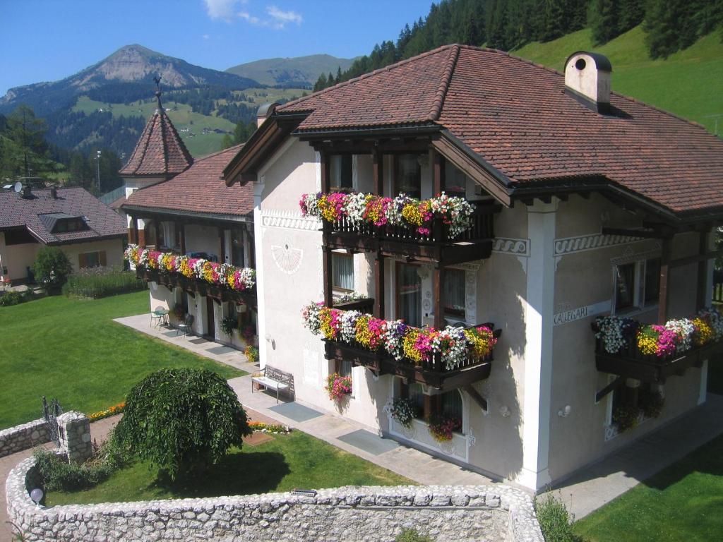 ein Gebäude mit Blumenkästen an den Fenstern in der Unterkunft Residence Cesa Callegari in Wolkenstein in Gröden