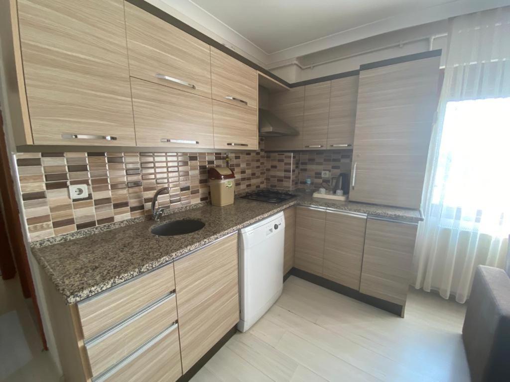 a small kitchen with wooden cabinets and a sink at My Rezidance Hotel in Manisa