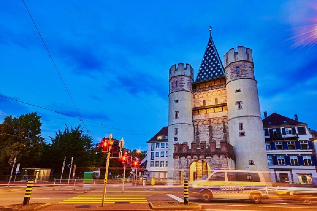 un edificio del castillo con una furgoneta estacionada frente a él en XL City Center Apartment-contactless check-in Netflix Included, en Basilea
