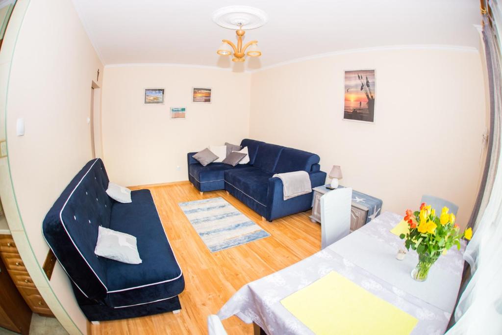 a living room with a couch and a table at Apartament U Rybaka in Łeba